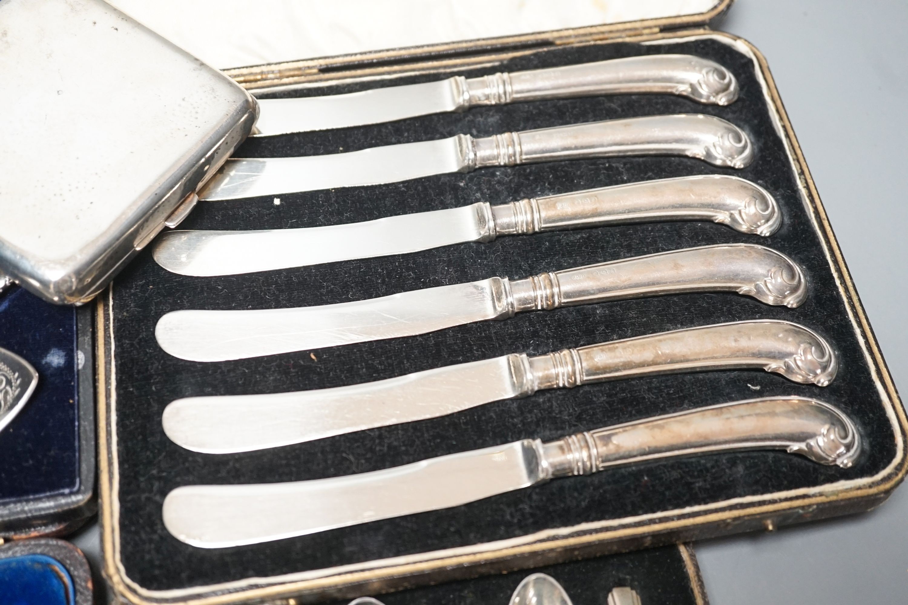 Four cased sets of cutlery including silver teaspoons and pair of silver preserve spoons and a silver cigarette case.